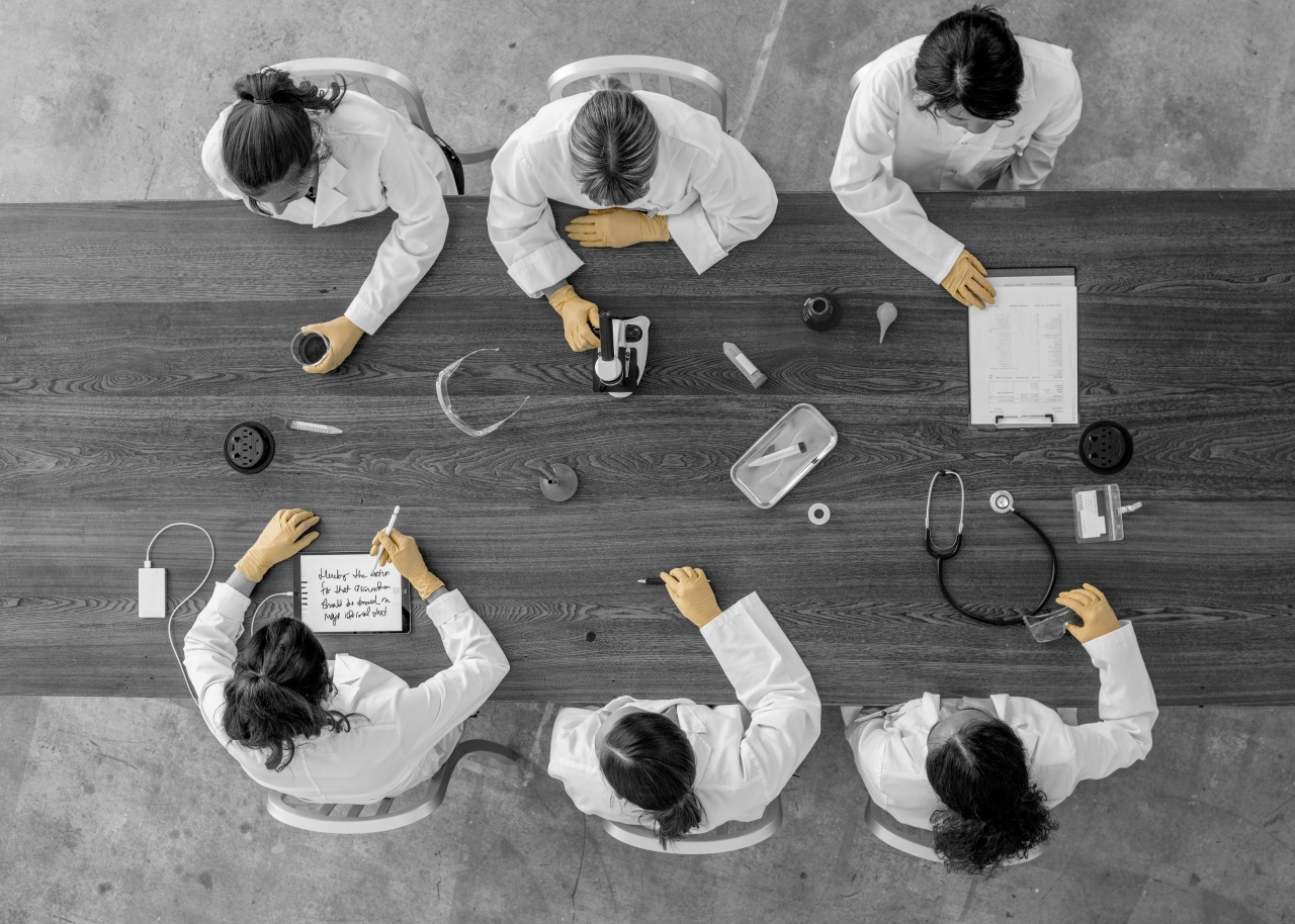 Doctors sitting at table with medical equipment